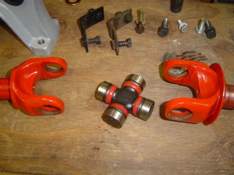 1989 Ford Bronco - Universal joint and driveshaft yokes laid out on a workbench, possibly for repair or replacement.