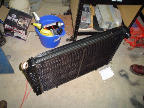 1984 Ford Bronco - Radiator part on floor, with cleaning supplies and tools in background.