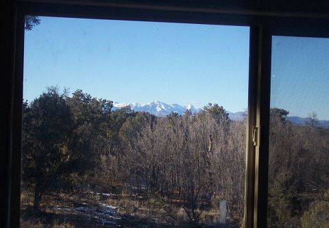 1986 Ford Ranger - A clear blue sky overlooks a forest with snow on the distant mountain peaks.