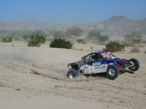 Purple and blue Tatum race buggy sliding through a desert turn