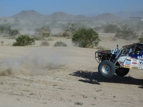 Rear view of number 1006 race buggy speeding away in the desert