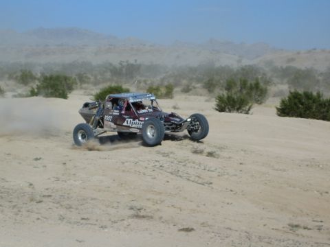 Maroon Alpine number 1007 race buggy on a desert course