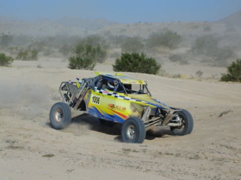 Yellow and blue All In number 1006 race buggy in the desert