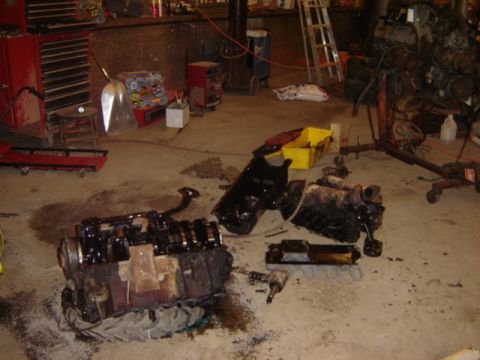 1992 Ford Bronco - Engine components are scattered across the floor of a workshop, suggesting a repair or rebuild in progress.