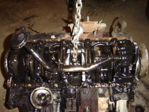 1992 Ford Bronco - This engine block is covered in oil and grime, showing the crankshaft and connecting rods.