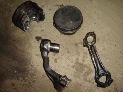 1992 Ford Bronco - Damaged engine components lie on a concrete surface.