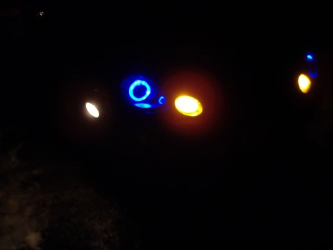 1998 Ford Taurus - Headlights with blue halo accents and orange marker lights are visible in the dark.