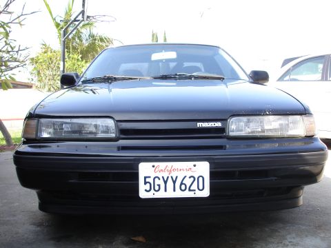 1989 Mazda MX-6 - Front view of a black 1989 Mazda MX-6 parked outdoors.