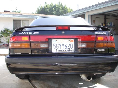 1989 Mazda MX-6 - Rear view of a 1989 Mazda MX-6 Turbo showing its taillights, spoiler, and dual exhaust pipes.