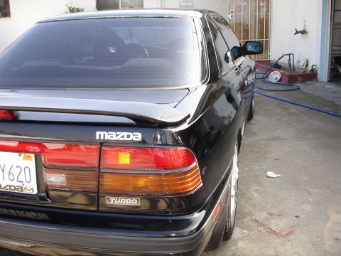 1989 Mazda MX-6 - Rear view of a black 1989 Mazda MX-6 Turbo, showing its distinctive taillights and spoiler.