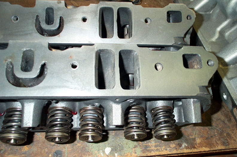 Engine cylinder heads with valve springs visible, Supermotors.net logo
