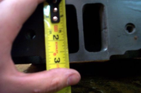 1978 Dodge Power Ram - Close-up of a cylinder head part with a tape measure indicating its dimensions.