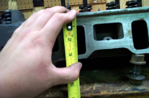 1978 Dodge Power Ram - A tape measure is used to check the dimensions of an engine cylinder head.