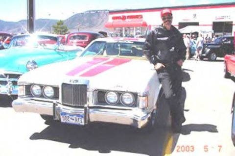 1972 Ford Ranchero - A man poses with a classic 1972 Ford Ranchero at an outdoor car show.