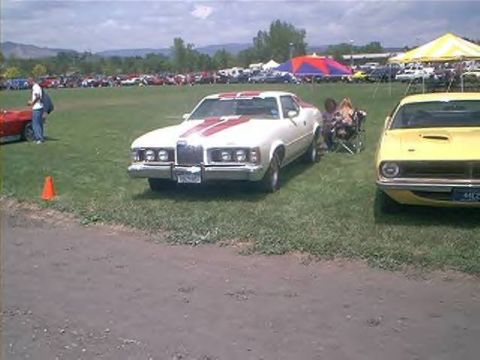 1972 Ford Ranchero - White 1972 Ford Ranchero with red racing stripes at a car show.