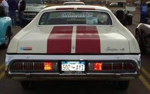 1972 Ford Ranchero - Rear view of a 1972 Ford Ranchero with distinctive red racing stripes and a chrome bumper.