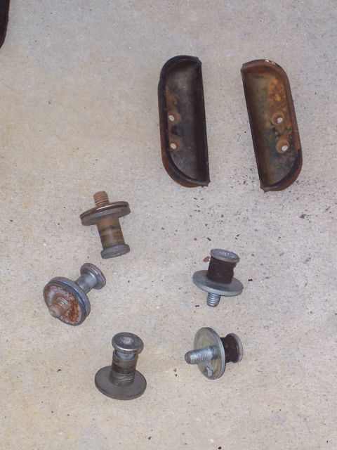1978 Ford Bronco - Assorted rusty fasteners and rubber pieces are laid out on a concrete surface.