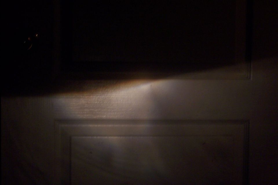 headlight beam shining on a paneled door