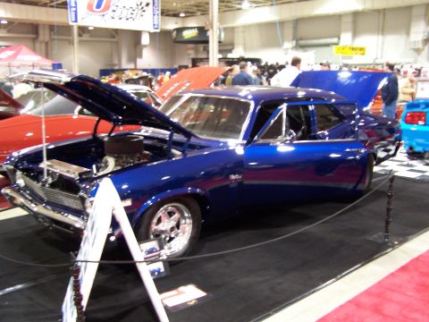 1995 Ford Probe - A blue classic car is displayed with its hood and trunk open at an indoor event.