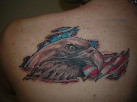 1995 Ford Bronco - A tattoo depicts an eagle's head emerging from a torn American flag on a person's upper back.
