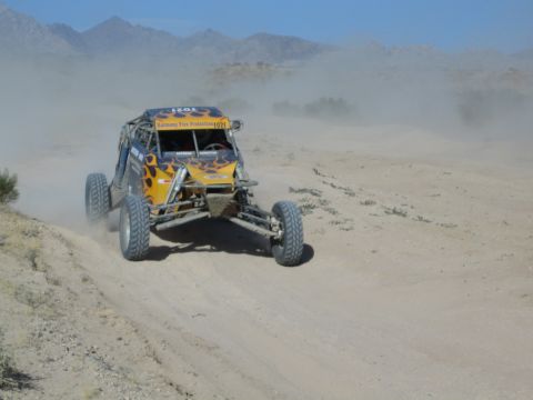 Off-road race buggy number 1021 with flame graphics in the desert