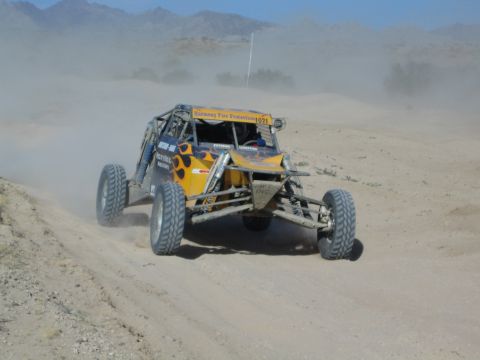 Orange and yellow off-road race buggy number 1021 in desert dust