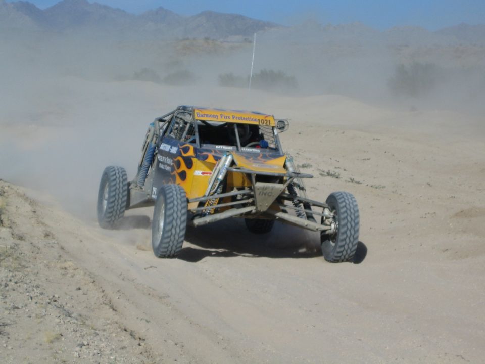 Orange and yellow off-road race buggy number 1021 in desert dust