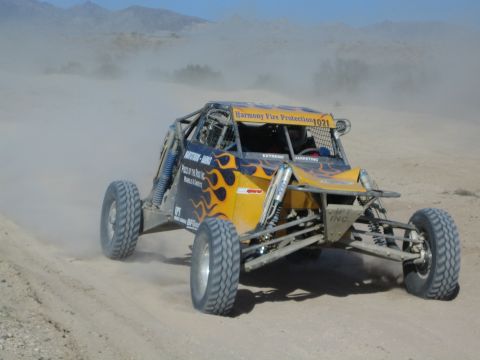 Yellow off-road race buggy with flame graphics number 1021 in the desert