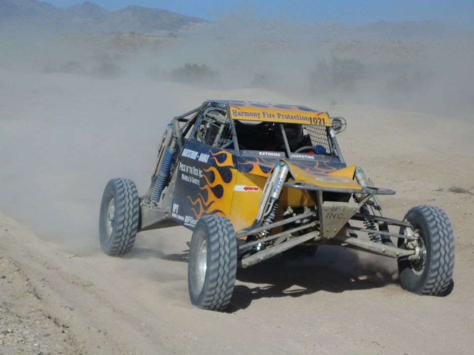 Yellow off-road race buggy with flame graphics number 1021 in the desert