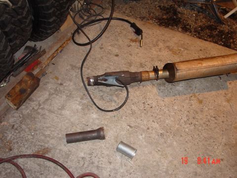 2004 Jeep Wrangler - A vehicle exhaust pipe is shown on the floor with welding equipment and spare parts nearby.