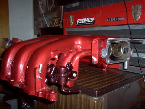 1994 Ford Probe - A red intake manifold, likely for a performance application, is shown with a visible throttle body and fuel pressure regulator.