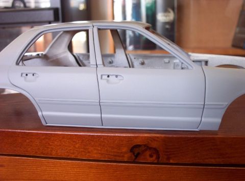 1998 Ford Crown Victoria - Unpainted model car body shown from the side, likely a sedan.