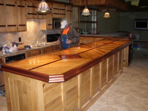 1995 Ford Bronco - A man stands in a kitchen area with a large wooden bar and custom cabinetry.