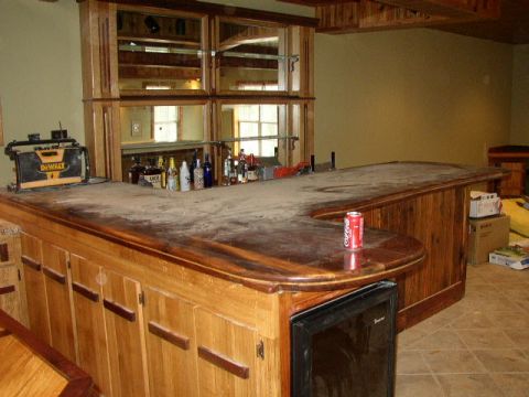 1995 Ford Bronco - Interior view of a home bar a horseshoe-shaped counter, liquor bottles, a mini-fridge, and a Coca-Cola can.