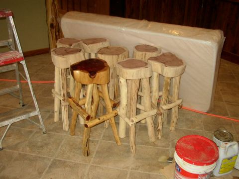 1995 Ford Bronco - A collection of handmade wooden bar stools and a covered mattress are visible in a room with tiled flooring and a ladder nearby.