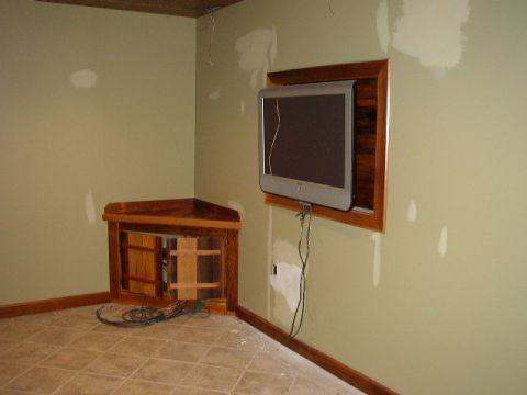 1995 Ford Bronco - An interior scene shows a television mounted in a wall opening above a wooden corner cabinet with exposed wiring.