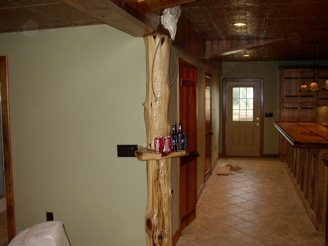 room with wood pillar, cans of soda, and a door