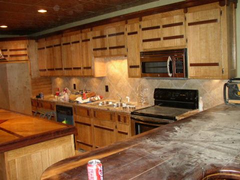 1995 Ford Bronco - A cluttered kitchen scene features wooden cabinetry, a microwave, and a stove, with a can of soda on the foreground counter.