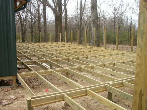 1995 Ford Bronco - The unfinished wooden frame of a deck is visible, with a green building and trees in the background.