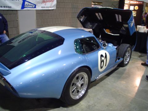 1984 Ford Bronco - A blue race car with white stripes and the number 61 is displayed with its hood open.