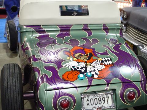 1984 Ford Bronco - Custom hot rod with flame paint and skull graphic, seen next to another vehicle.