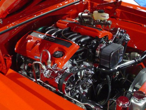 1984 Ford Bronco - Close-up of a custom engine with GTO branding, chrome detailing, and an exposed air filter in a red vehicle.