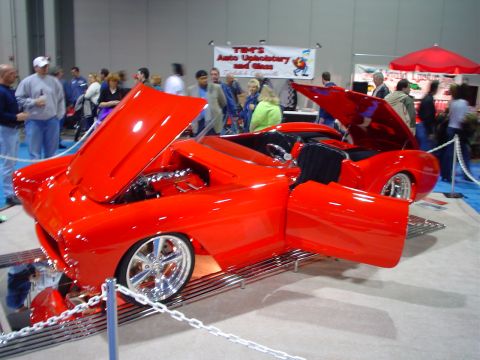 1984 Ford Bronco - Custom red convertible on display at a car show with its hood and doors open.