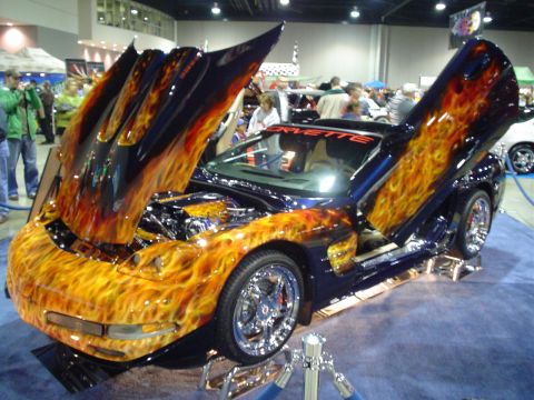 1984 Ford Bronco - Customized Chevrolet Corvette with a flame paint job displayed with its hood and doors open.