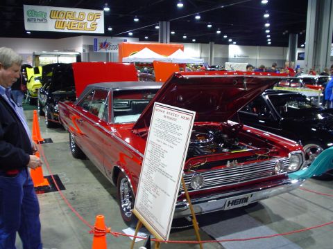 1984 Ford Bronco - A red coupe with its hood open is displayed at a car show, with a sign detailing its "Mopar Street Hemi" specifications.