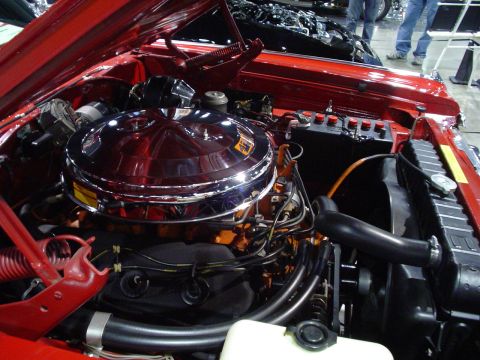 1984 Ford Bronco - Close-up of a red vehicle's engine bay, a prominent chrome air cleaner and various engine components.