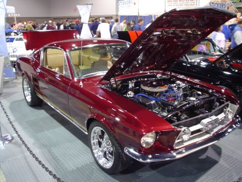 1984 Ford Bronco - Customized 1967 Ford Mustang coupe on display at a car show, hood open to reveal the engine.