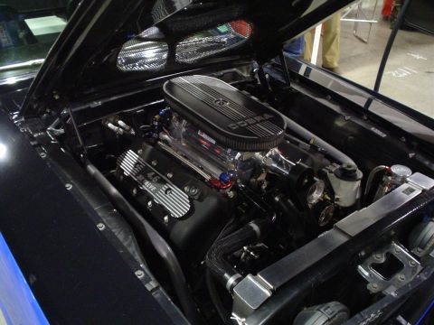 1984 Ford Bronco - The engine bay of a black vehicle displays a 4.6 32 valve engine with a Cobra air cleaner.