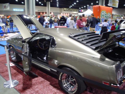 1984 Ford Bronco - A 1969 Ford Mustang coupe with black hood stripes and rear window louvers is displayed with its doors and hood open.