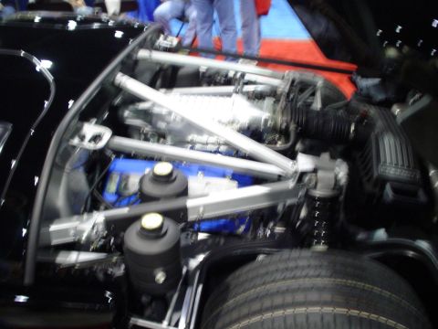 1984 Ford Bronco - Close-up of a modified engine bay a supercharger and custom bracing.